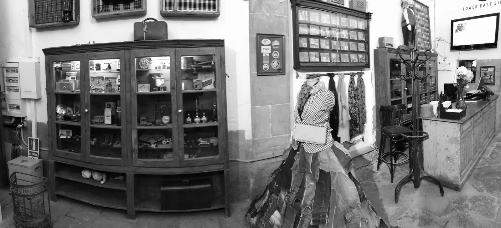 Schmale Gasse mit Vintage-Laden, Schaufenster mit Glasvitrinen, Puppe im blauen Jeanskleid
