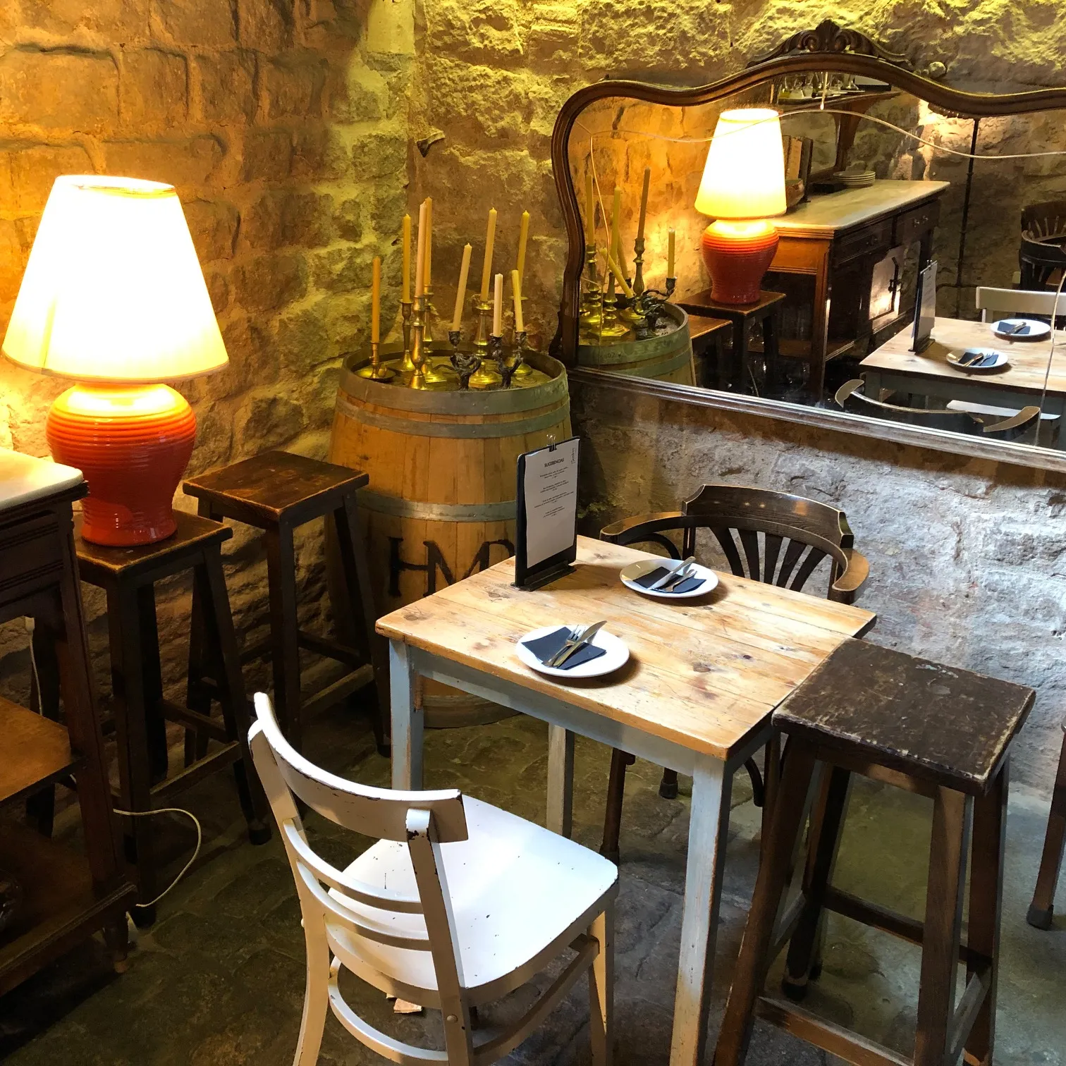 Gemütliches Restaurant mit Steinwänden, beleuchteten Tischlampen, gedeckten Tischen und rustikalem Flair im Kellergewölbe