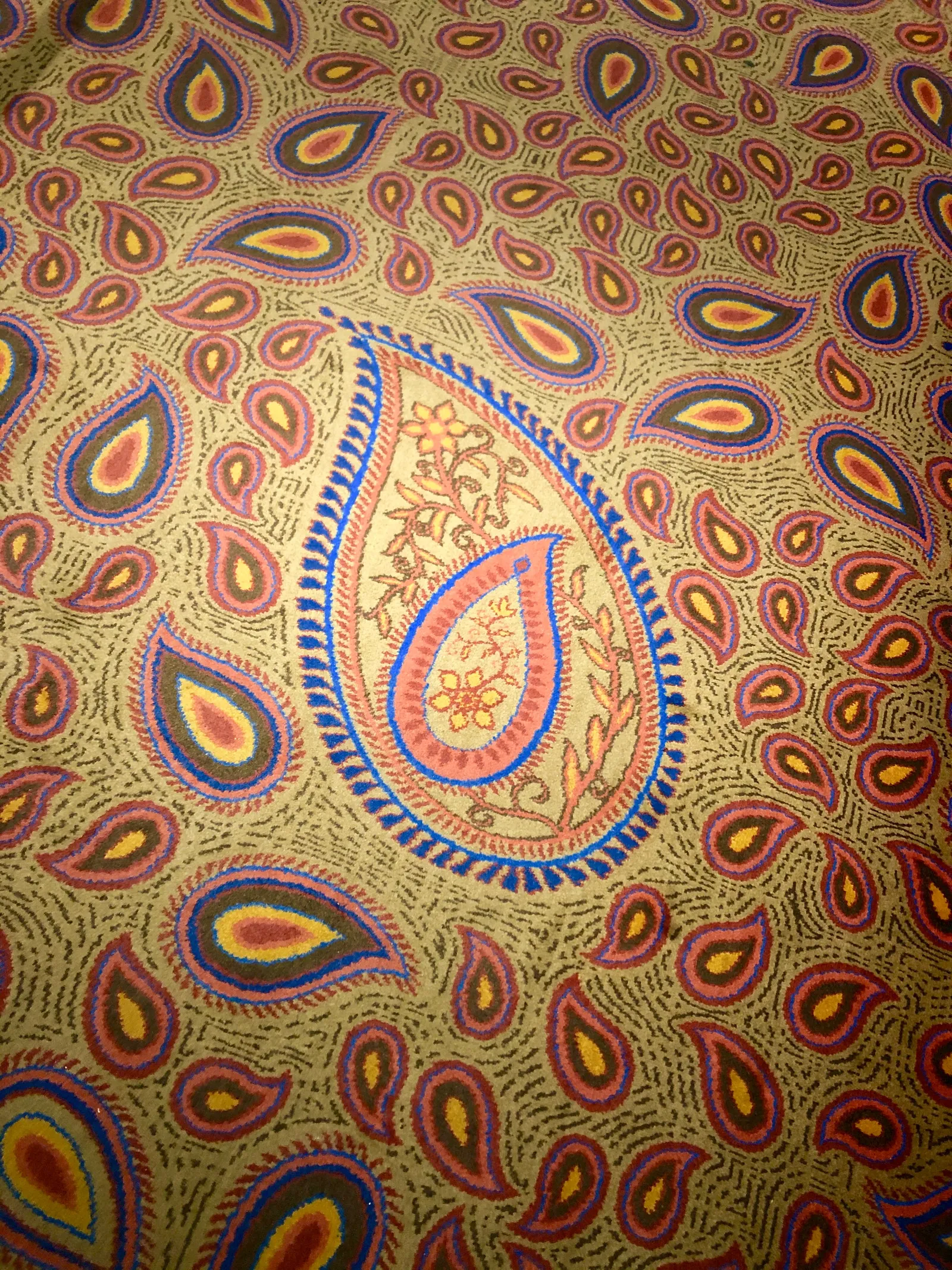 Ornamentales Muster mit goldenem Hintergrund, purpurroten und gelben Paisley-Motiven sowie einer größeren zentralen