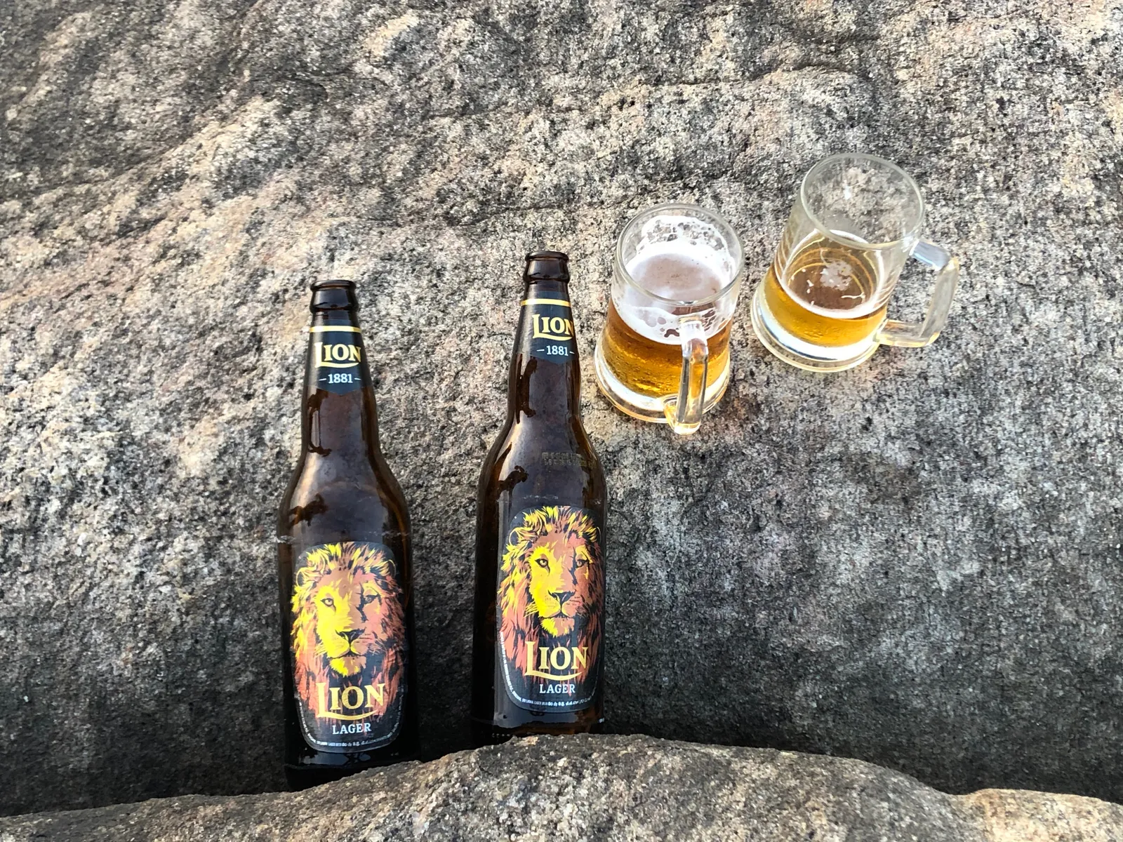 Zwei ION Lager Bierflaschen und zwei gefüllte Gläser auf Steinuntergrund in Sri Lanka