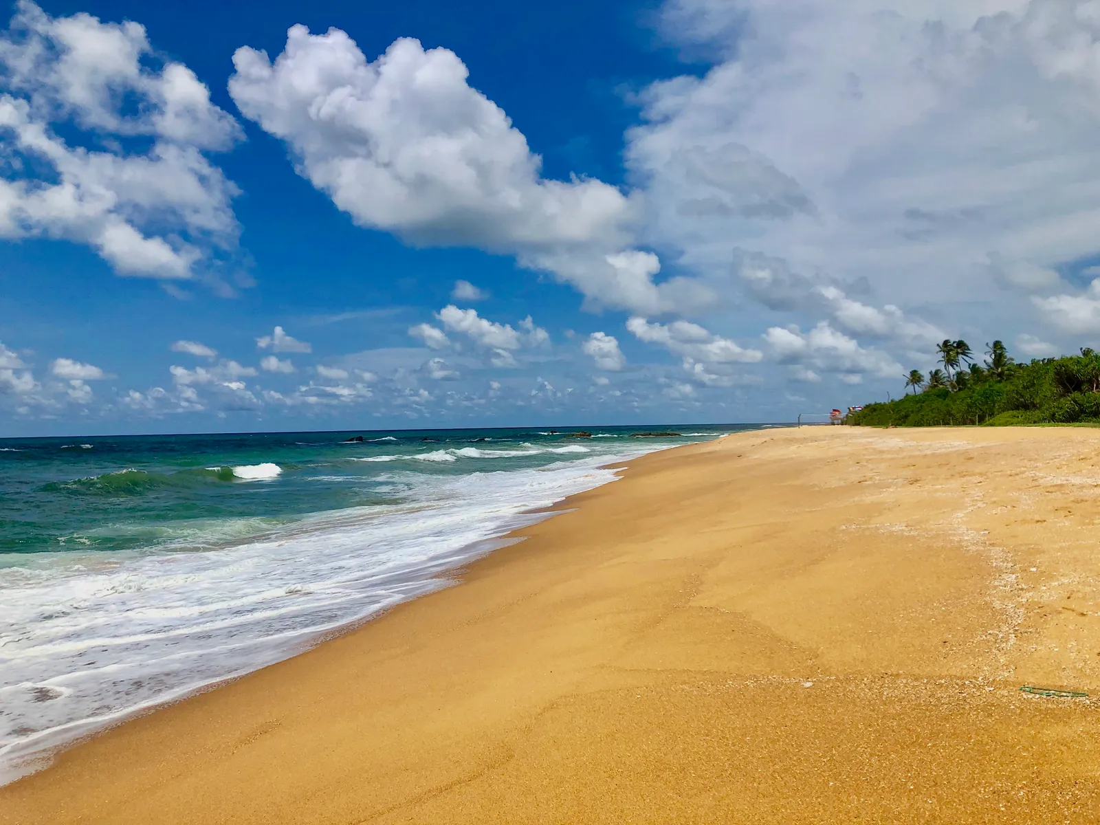 Menschenleerer Traumstrand an der Westküste mit goldgelbem Sand, türkisblauem Meer