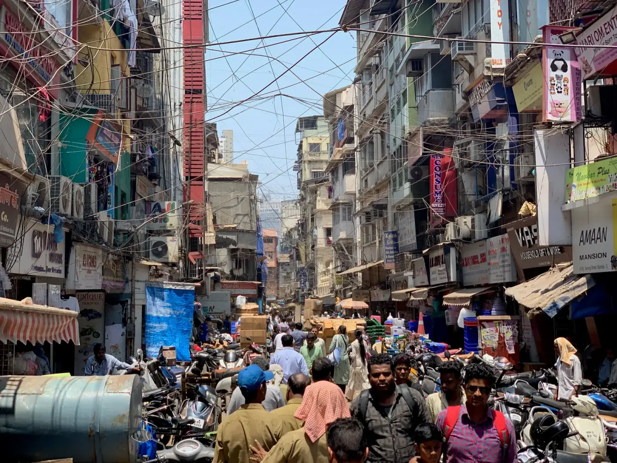 Überfüllte Marktstraße in einer indischen Stadt mit eng beieinander stehenden Menschen