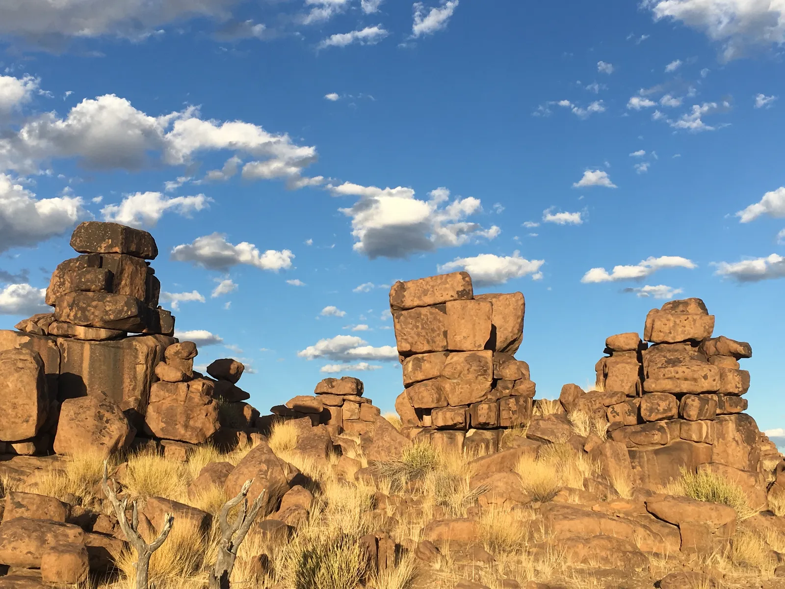 Bizarre Granitfelsblöcke stapeln sich natürlich übereinander in der namibischen Wüstenlandschaft unter blauem Himmel