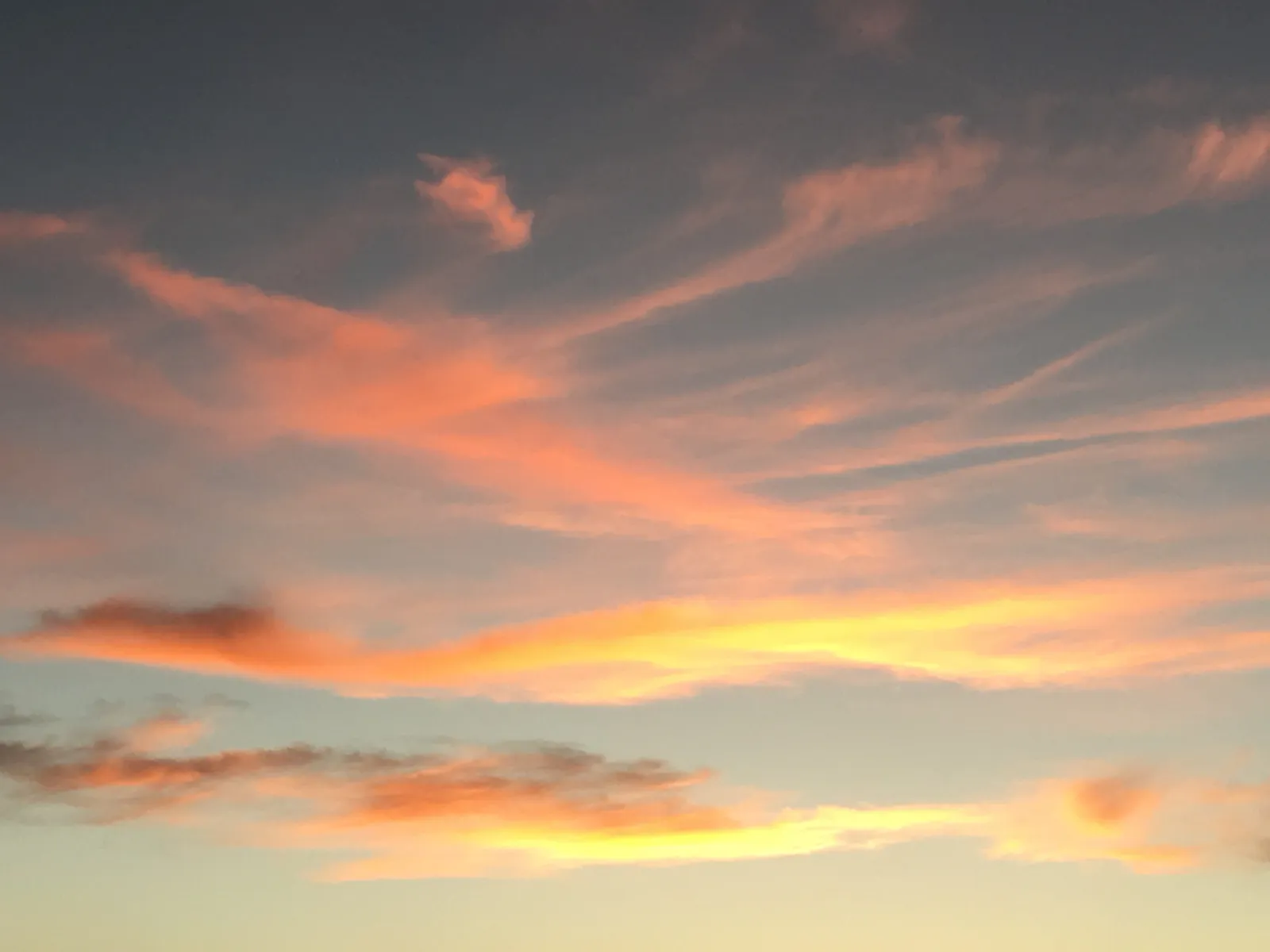 Dramatischer Sonnenuntergang mit leuchtend orange-gelben Wolkenstreifen am namibischen Himmel