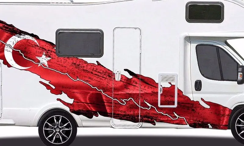 Wohnmobil mit rotem Landkarten-Motiv auf der Seite, symbolisiert Reise und Abenteuer