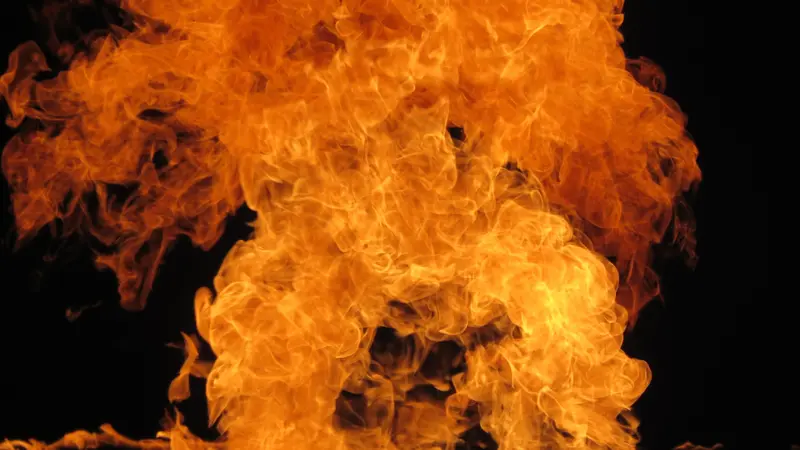 Intensive Flammen lodern in Orange- und Rottönen gegen schwarzen Hintergrund auf