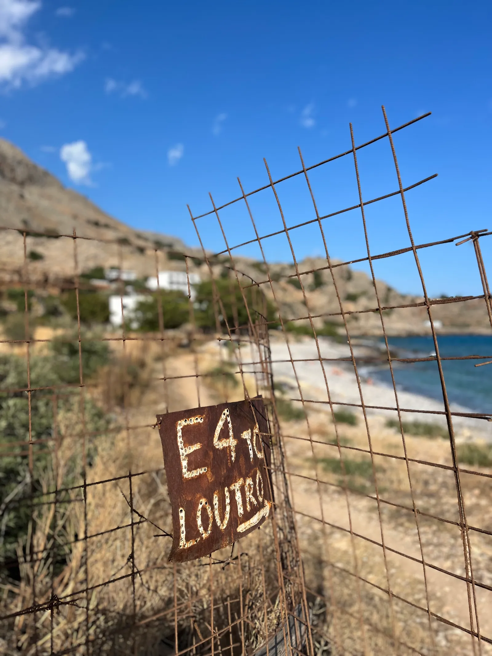 Rostiges Schild mit Aufschrift „54 LOUTRO" an einem Drahtgitter