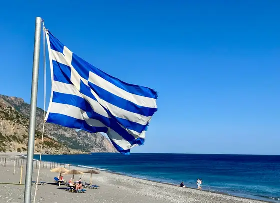 Griechische Flagge über dem Strand
