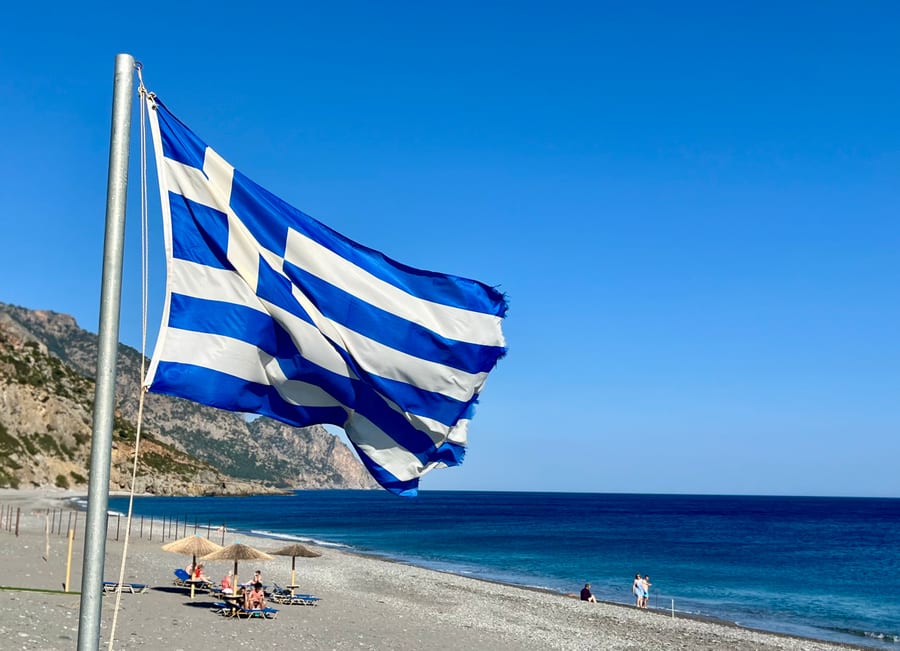 Griechische Flagge über dem Strand